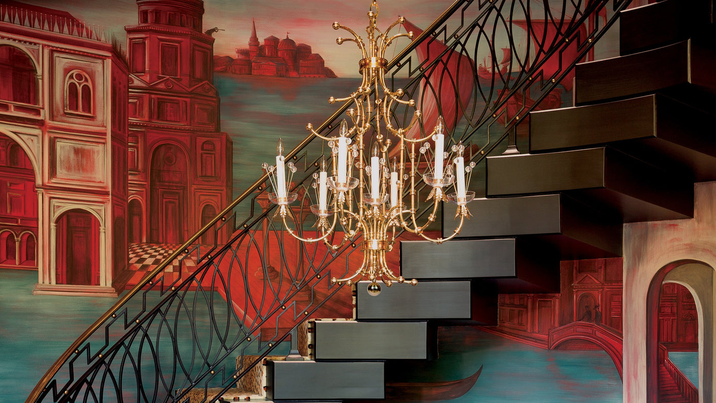 The Contessa Chandelier by Tony Duquette for Remains Lighting Co. hangs in an oval stairway, its walls painted with scenes depicting Venice, Italy.