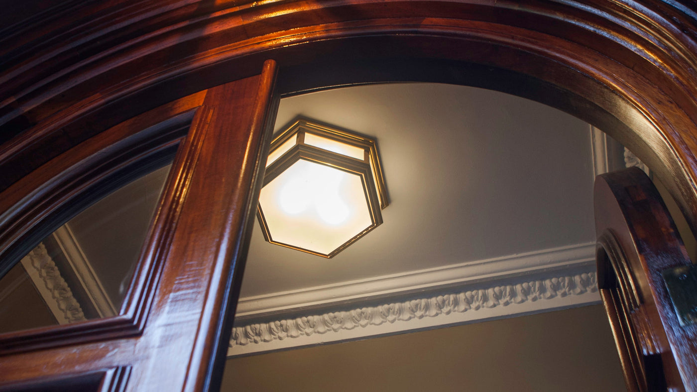 A Hexagonal Philip Flush Mount in Antique Brass finish on the ceiling of a Brooklyn Heights entry vestibule.