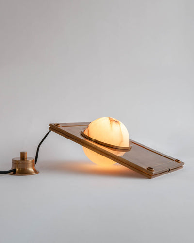 M.Fisher Collection image 1 of a Nima Table Light made-to-order.  Shown lit in Antique Brass with Black fabric wire.