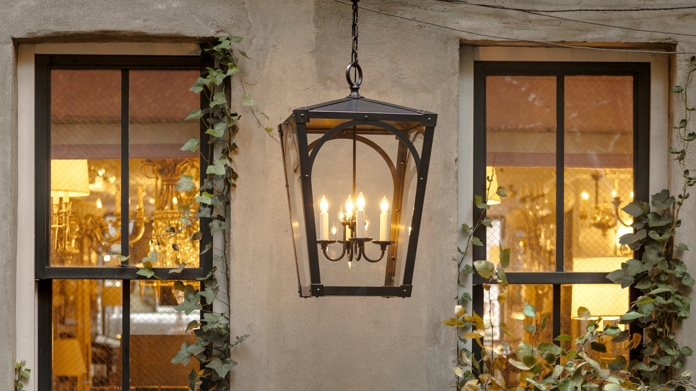 A Mercer 26 Exterior Lantern in Dark Waxed Bronze by Remains Lighting Co. hangs in an ivy-clad rear garden on New York City's Upper East Side.