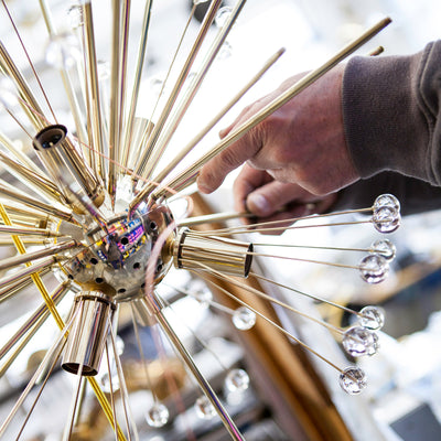 A detail shot of a Polished Brass Tony Duquette Dandelion Chandelier being assembled at the Remains Lighting Co. Brooklyn factory.
