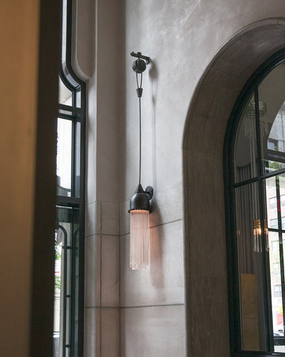 The entryway of the Beckford Residences on New York City's Upper East Side, featuring a unique acid-darkened aluminum wall armature with a large glowing tassle of acrylic rods suspended from it.