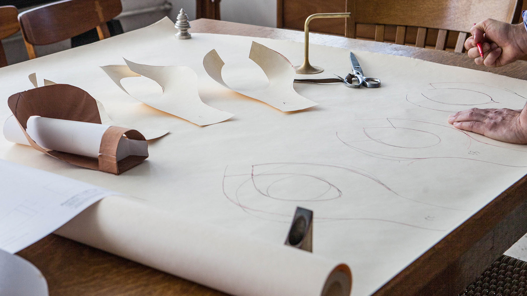 Sketches and paper and cardboard cut outs of shapes being used to design and mock up new fixture designs for the miner's lantern included in the Presidio by Hart Howerton lighting collection